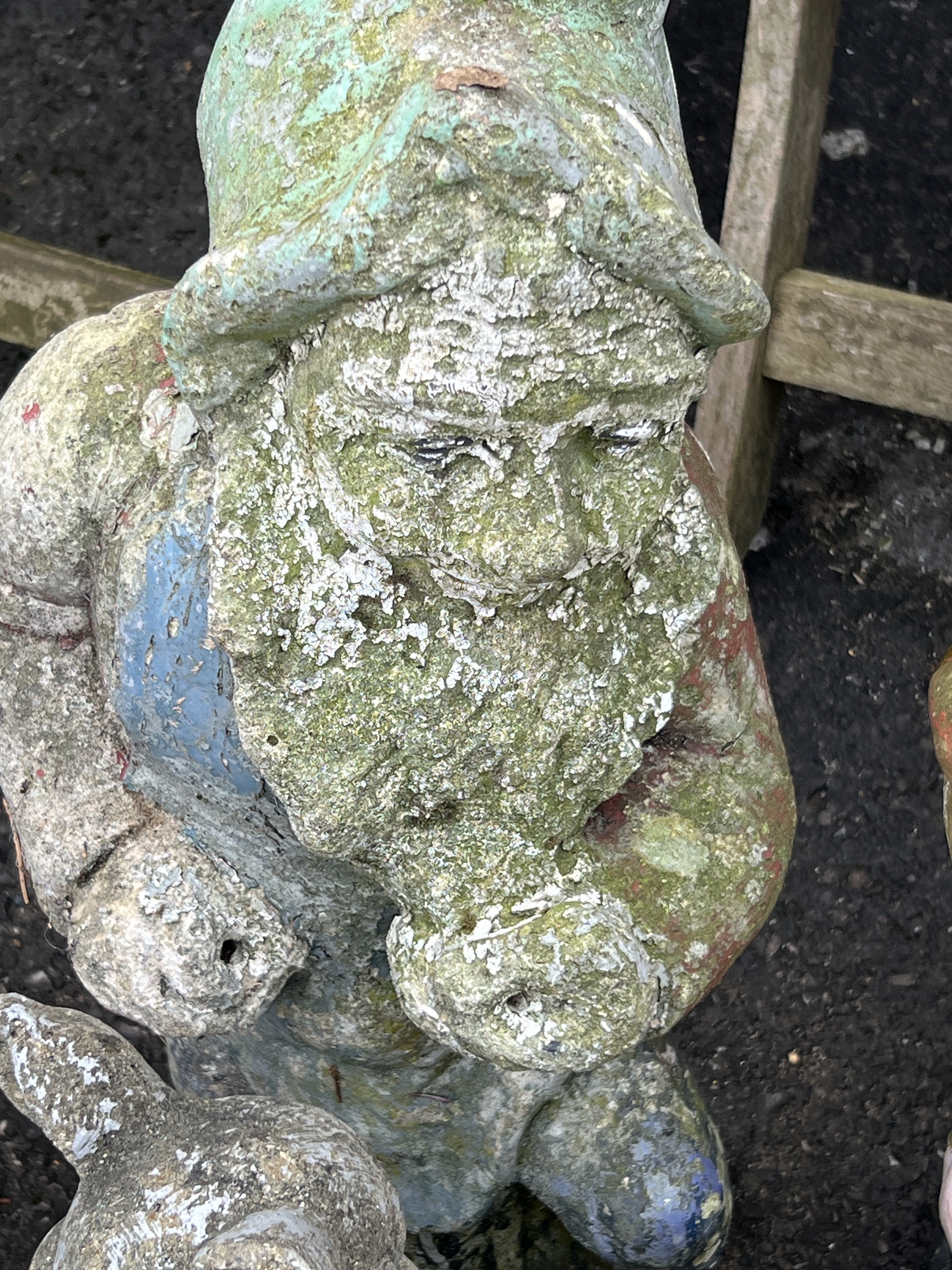 Two reconstituted stone and fibreglass gnome garden ornaments, larger height 65cm together with a seated pig garden ornament